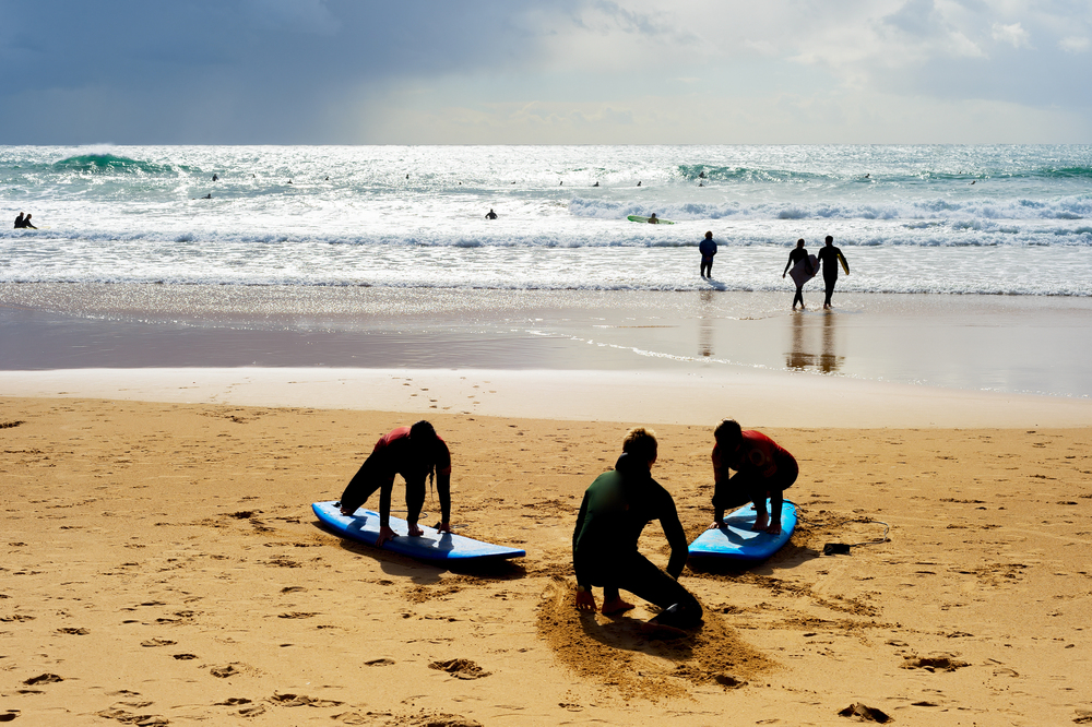 Surfing school learning taking surf lesson at the beach.